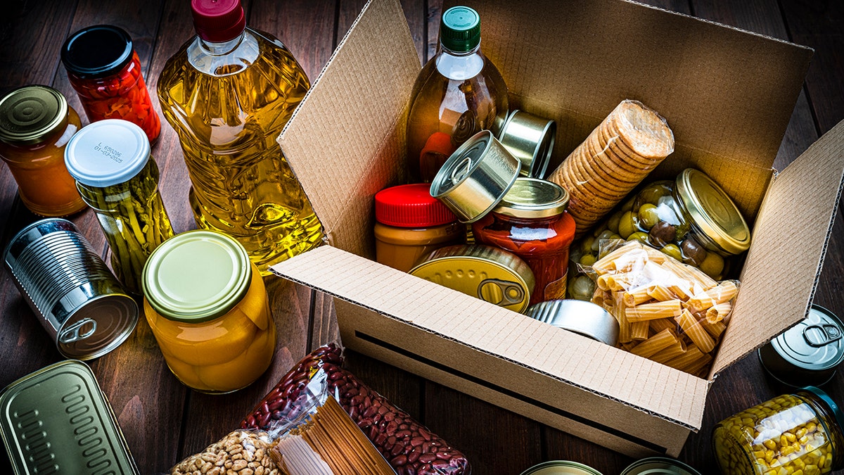 cardboard box filled with canned goods, sauces and oils