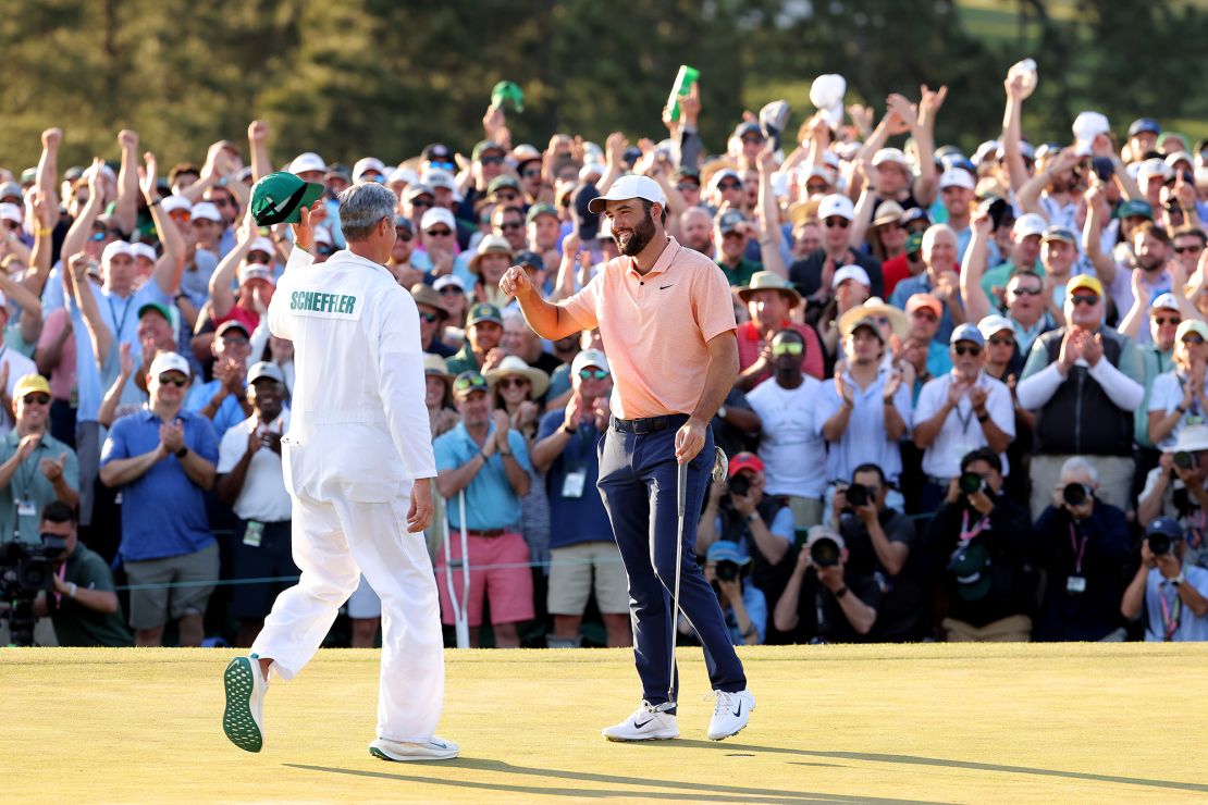 Scheffler and caddie Ted Scott celebrate on the 18th green after winning the Masters.