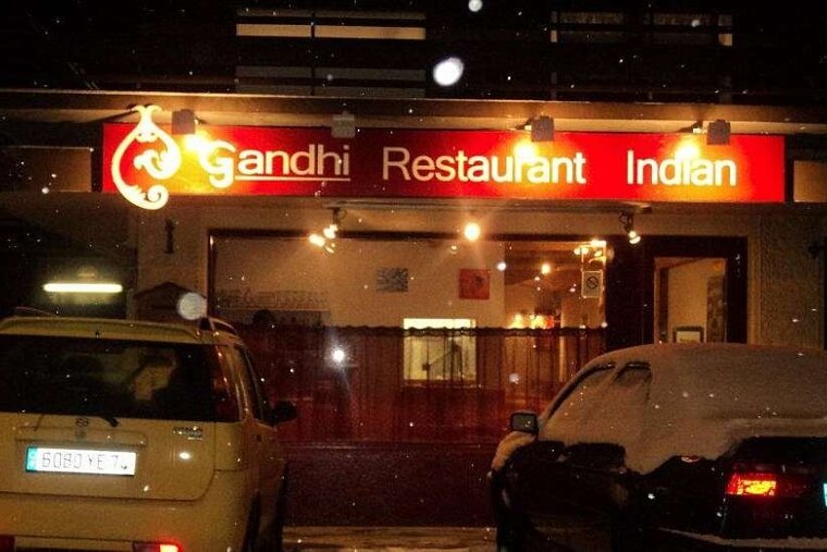 an image of the front of a restaurant with a red sign lit up