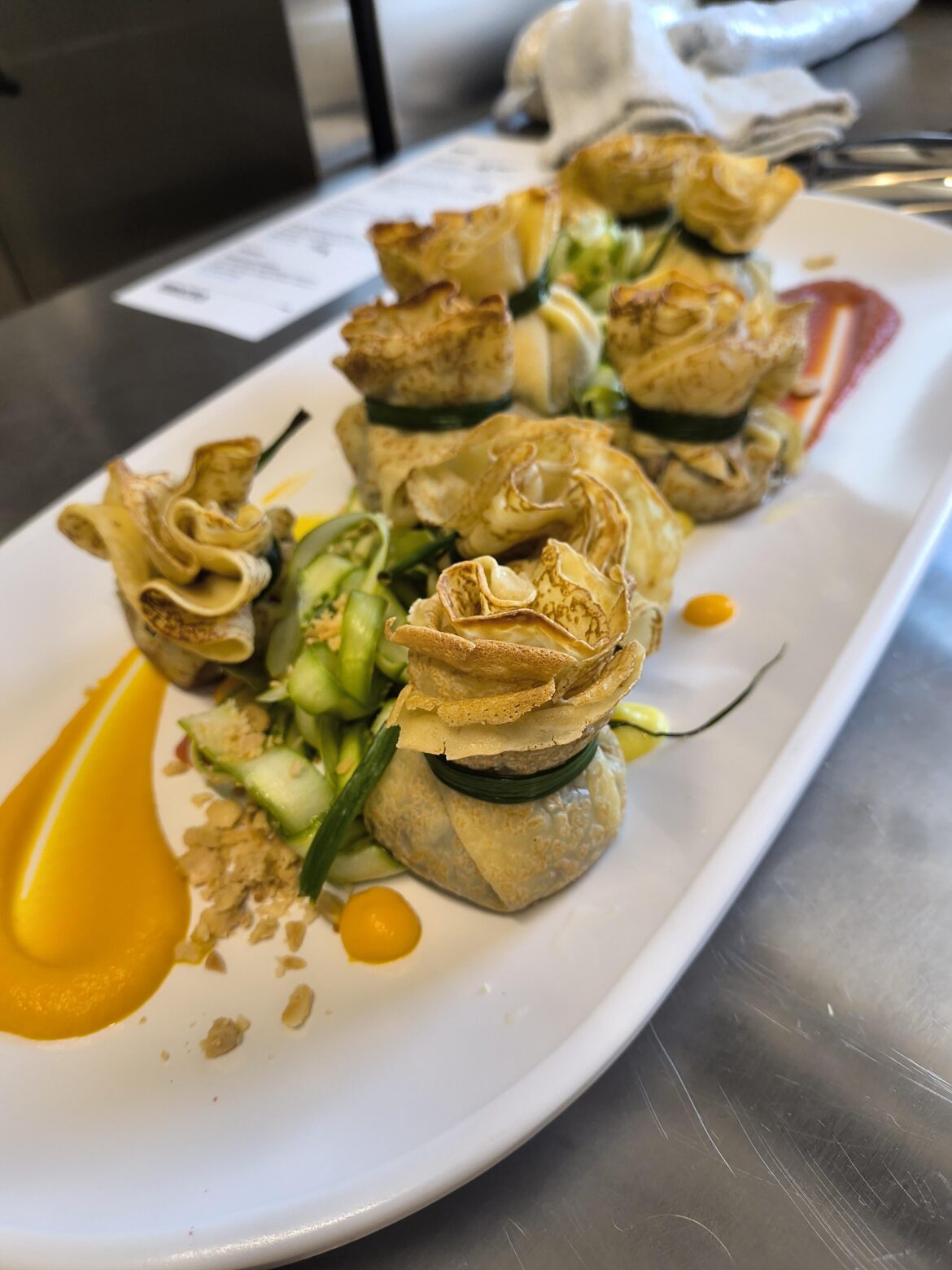 Duck confit beggars purses - crepes, duck confit/brie/fig filling, heirloom carrot agrodulce sauce, shaved asparagus, marcona almond