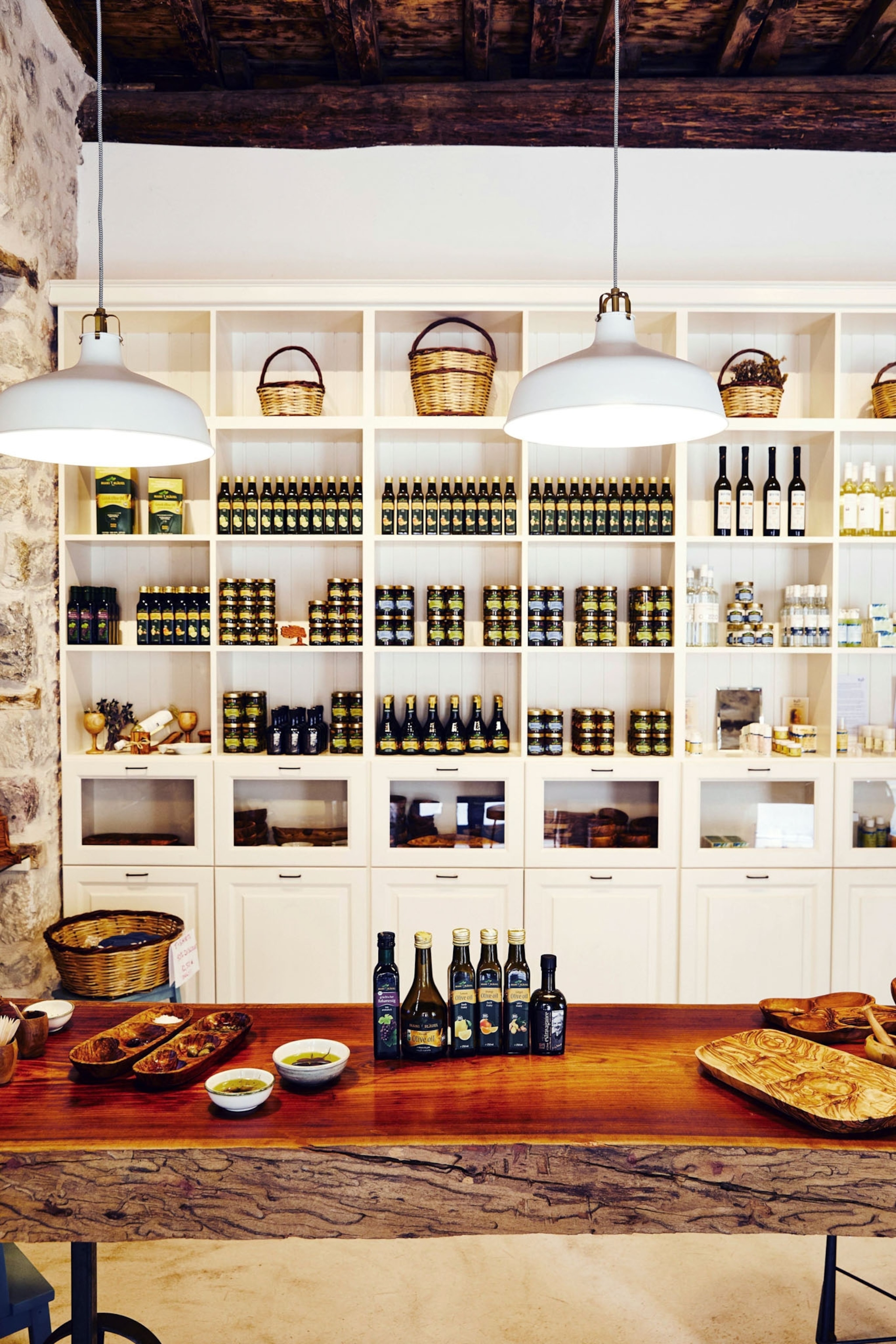 Multiple bottles of olive oil adorn the shelves of a store interior.