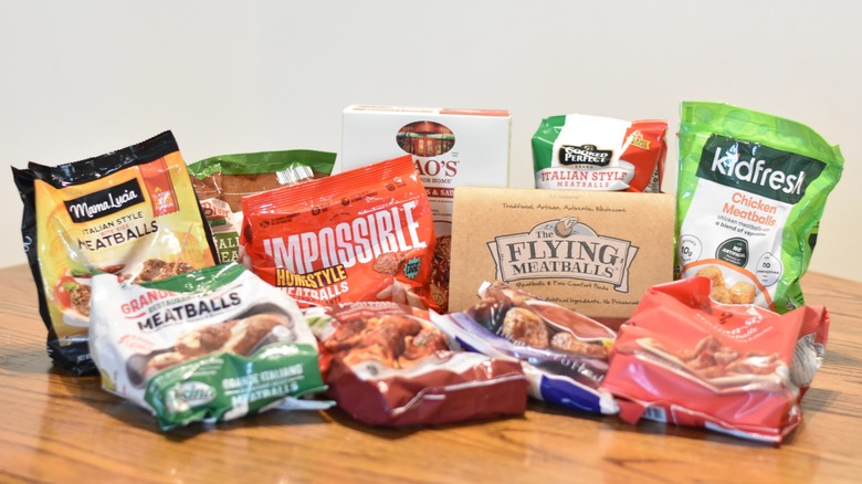 A selection of frozen meatballs in bags and packages on a wooden table