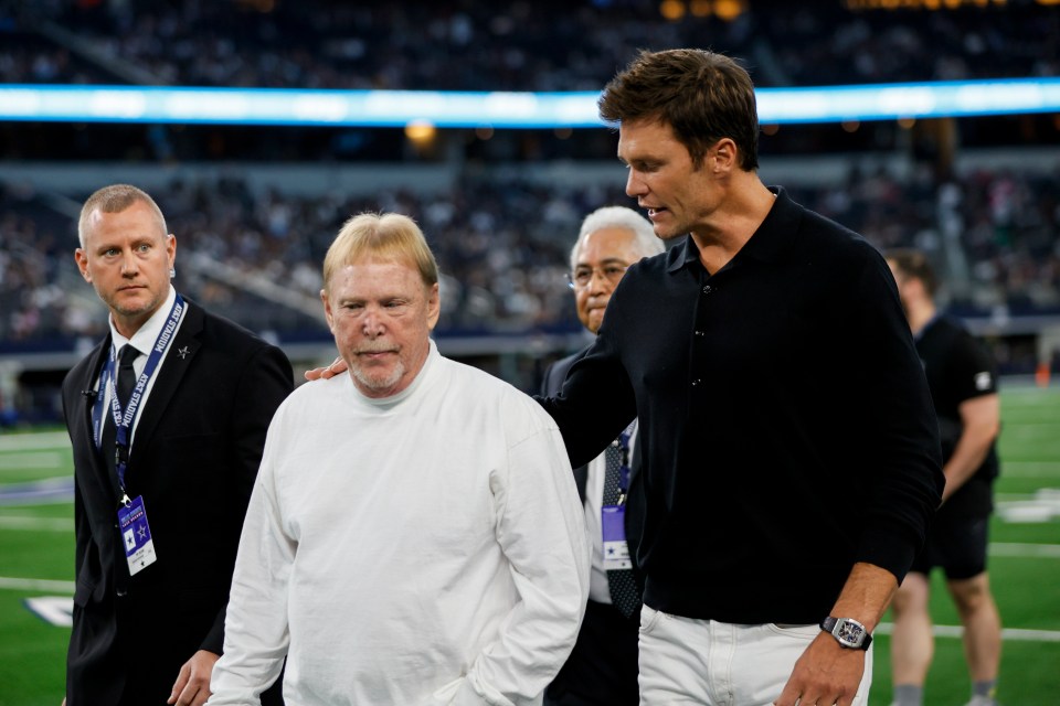 Mark Davis, owner of the Las Vegas Raiders, and Tom Brady walking on a football field.