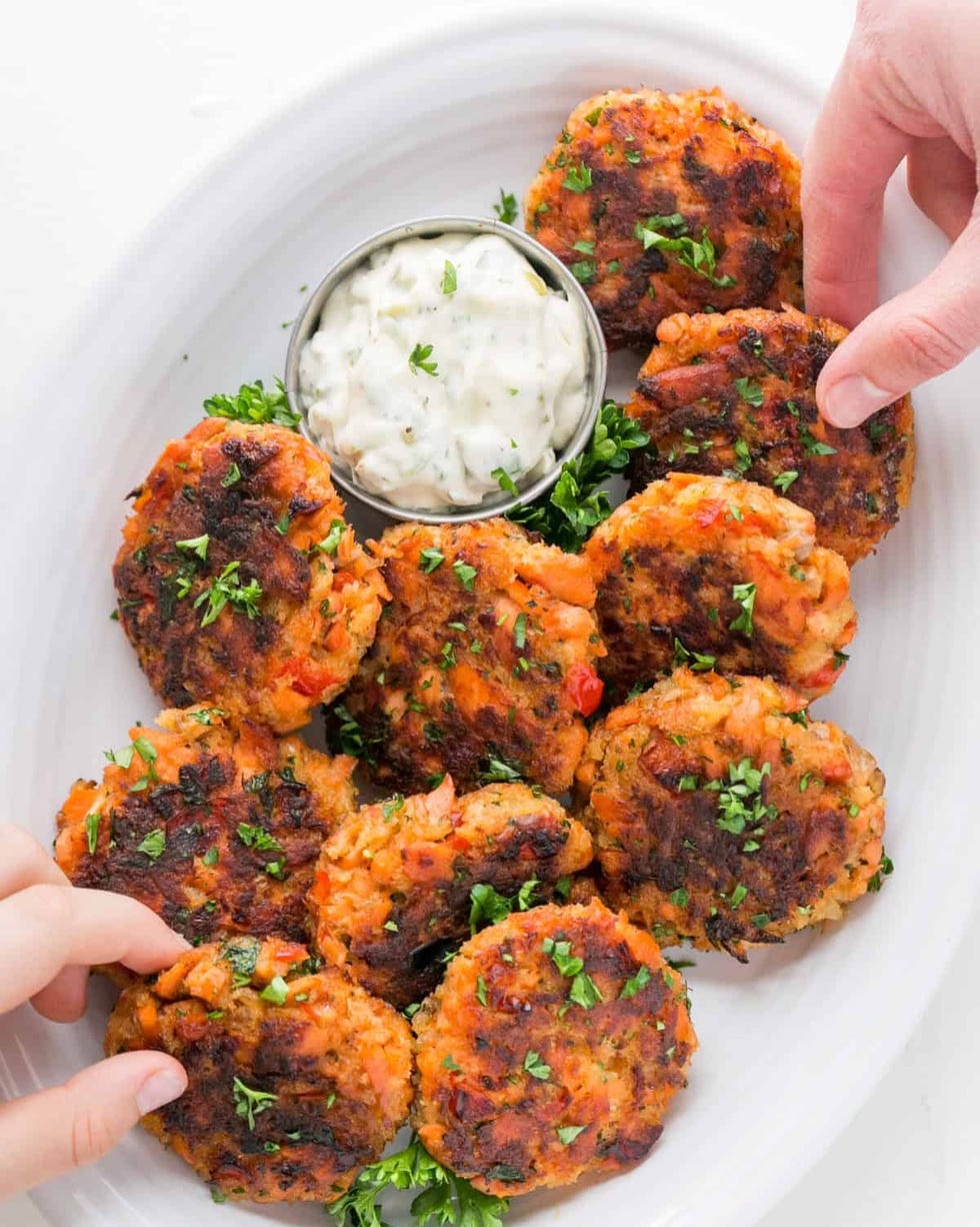 salmon cakes with dip and hands