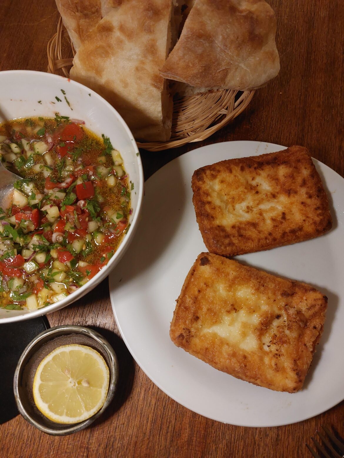 Cheese Saganaki with tomato cucumber salad and flatbread.