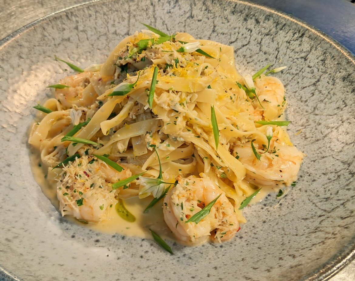 Cornish crab and prawn tagliatelle, with a white wine, cream and garlic sauce, garnished with three-cornered leek.