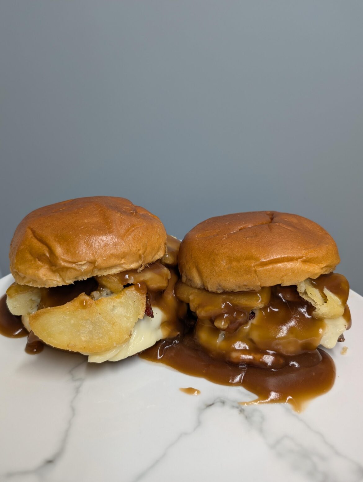 The upgraded gravy cheeseburger...bacon bits and crispy roast potatoes on top of two cheeseburgers, smothered in gravy.