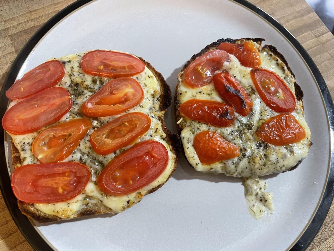 Cheesey garlic bread on toast topped with cherry tomatoes