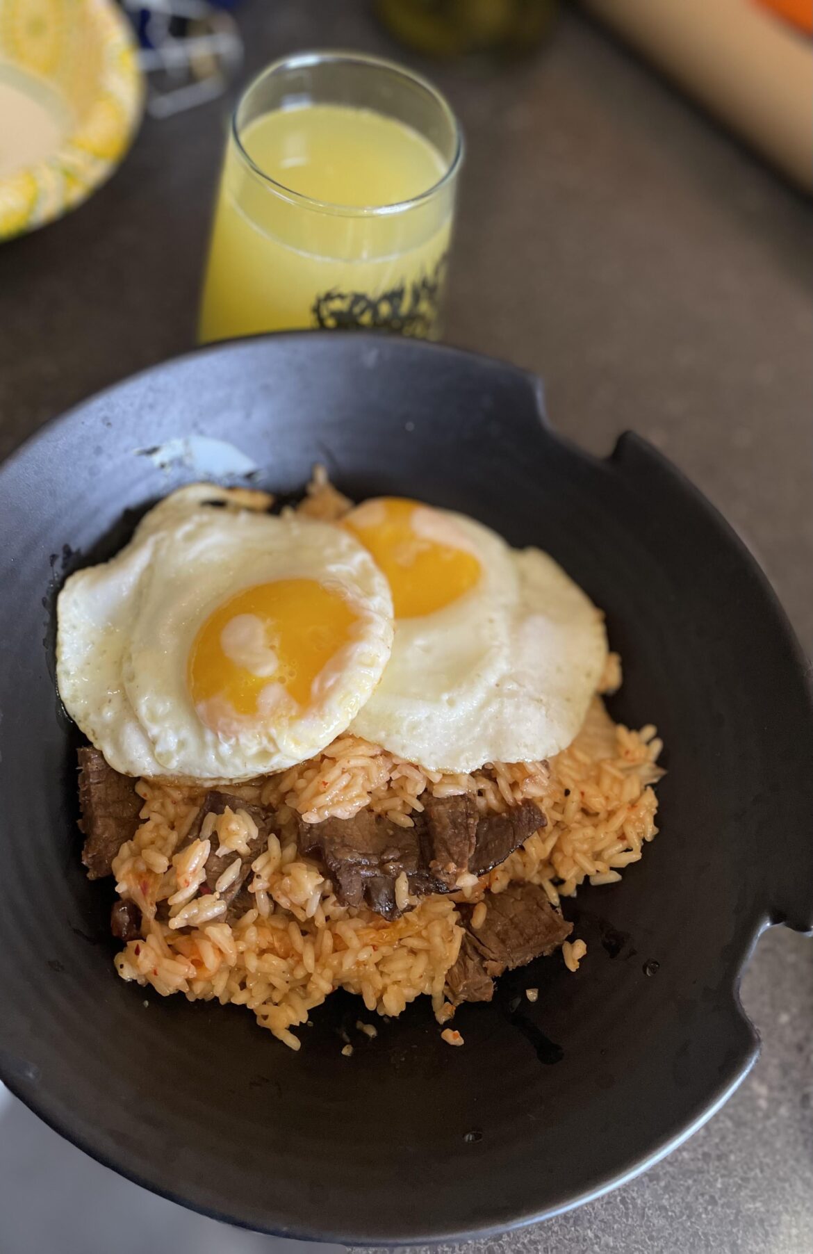 Kimchi rice bowl with marinated steak and fried eggs and mimosas