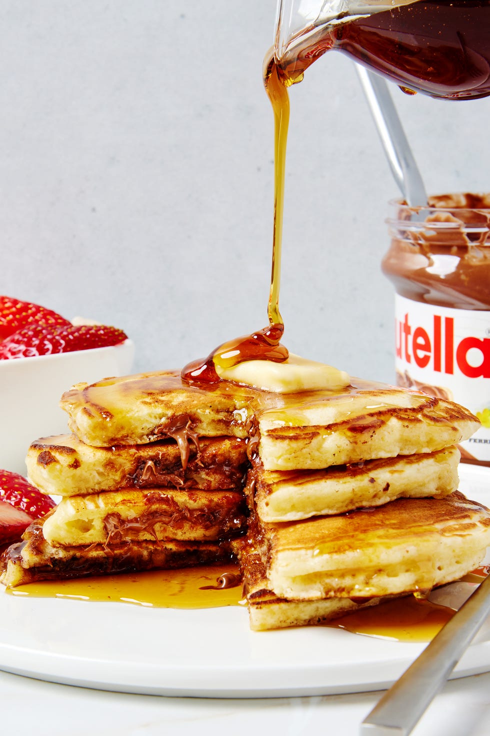 three pancakes stuffed with nutella and topped with butter and syrup