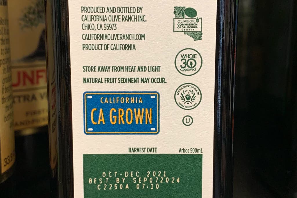 The sell by date on a bottle of olive oil.