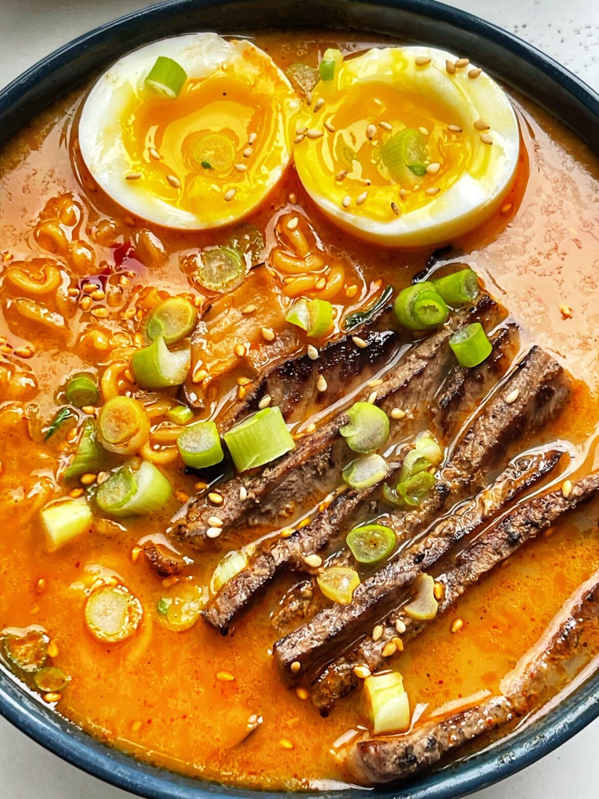 [homemade] spicy shin ramen with some New York strip, jammy eggs, sesame seeds and a little gochujang