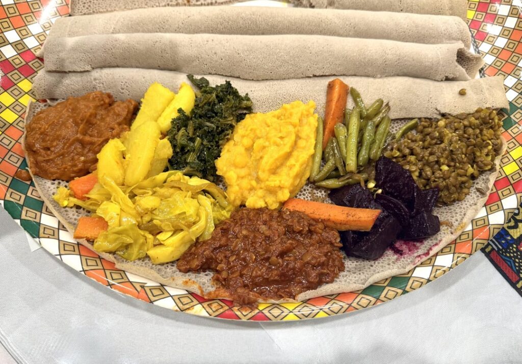 Ethiopian injera platter with injera bread and an assortment of freshly prepared vegetables, lentils and beans. An Ethiopian fusion restaurant in Southern California. Ethiopian injera platter with injera bread and an assortment of freshly prepared vegetables, lentils and beans. An Ethiopian fusion restaurant in Southern California.