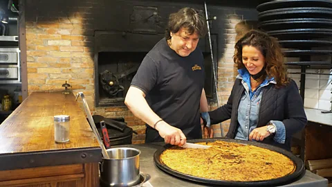 Chez Theresa At Nice's Chez Theresa, socca batter is poured onto a piping-hot pan, then cooked for 10 minutes (Credit: Chez Theresa)
