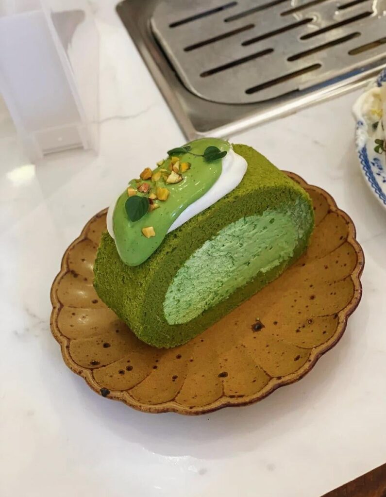 Coconut ombre cake roll with chopped pistachios.