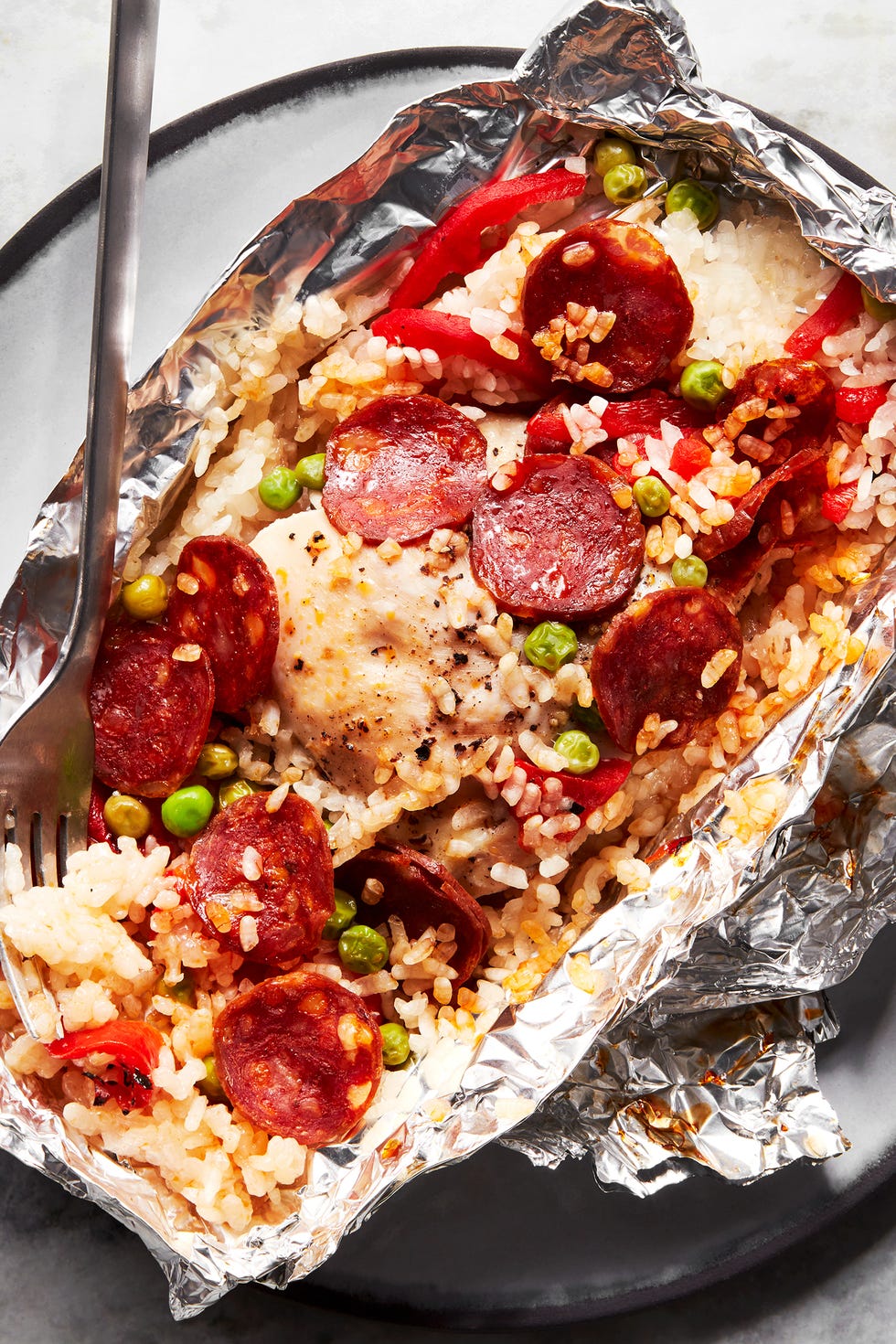 foil packs filled with rice, peas, pepperonis, and peppers
