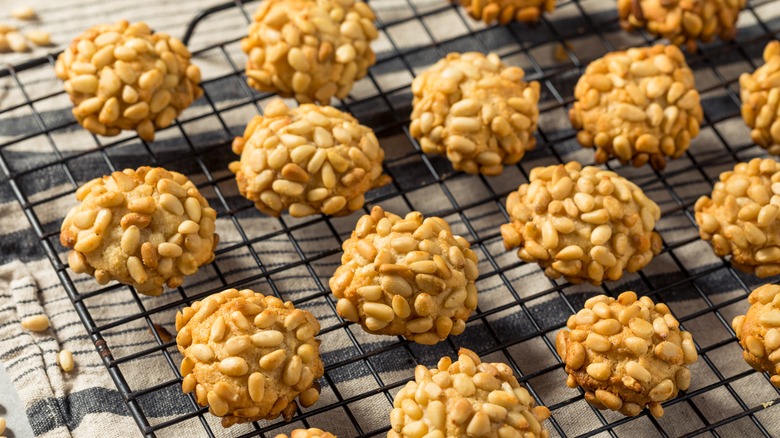 Small cookies covered in pine nuts and set out on a tray