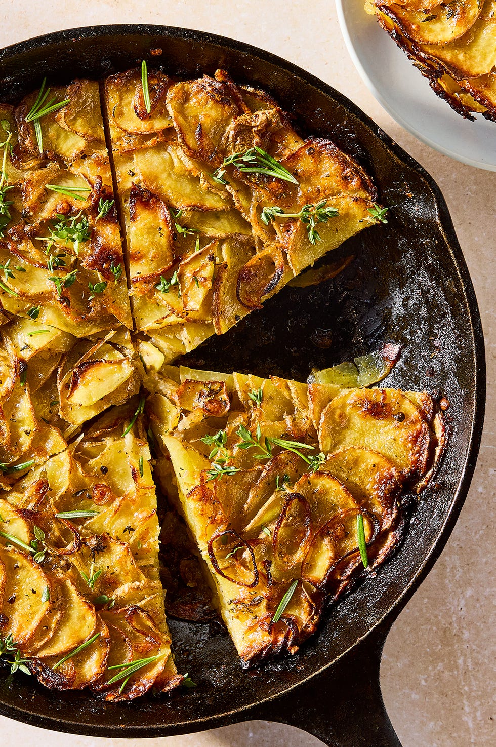 galette in a pan layered with thinly sliced potatoes