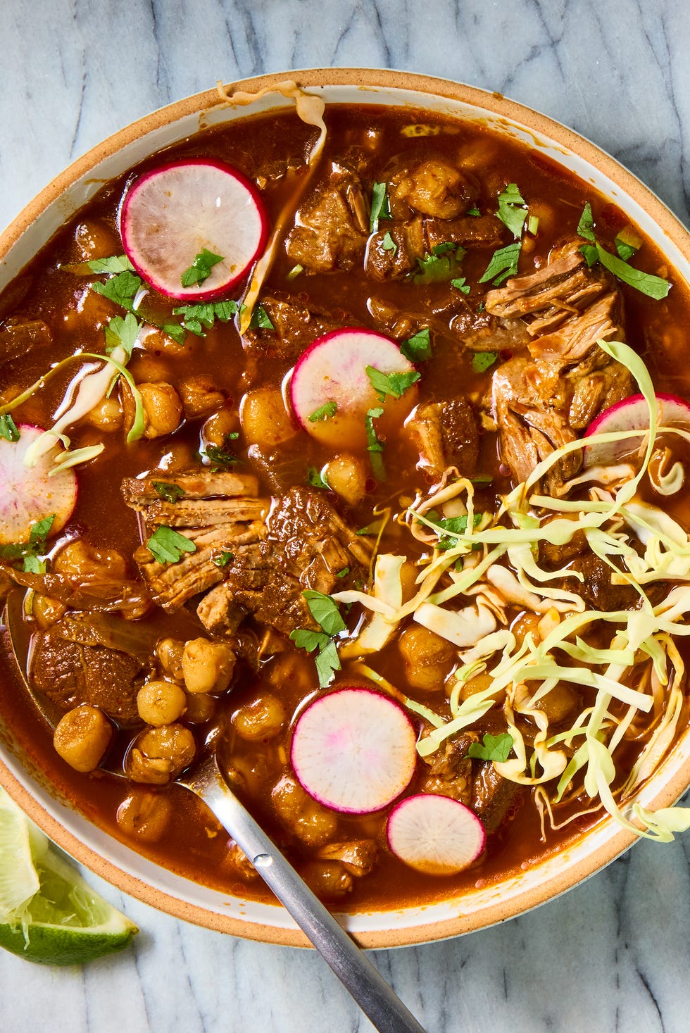 pozole with pork shoulder topped with cabbage and radishes