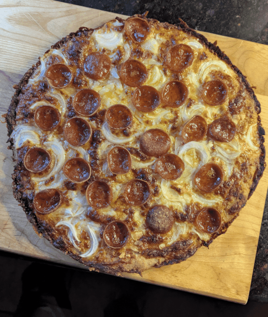 King Arthur keto pizza dough. Onions and pepperoni cooked in an iron skillet.