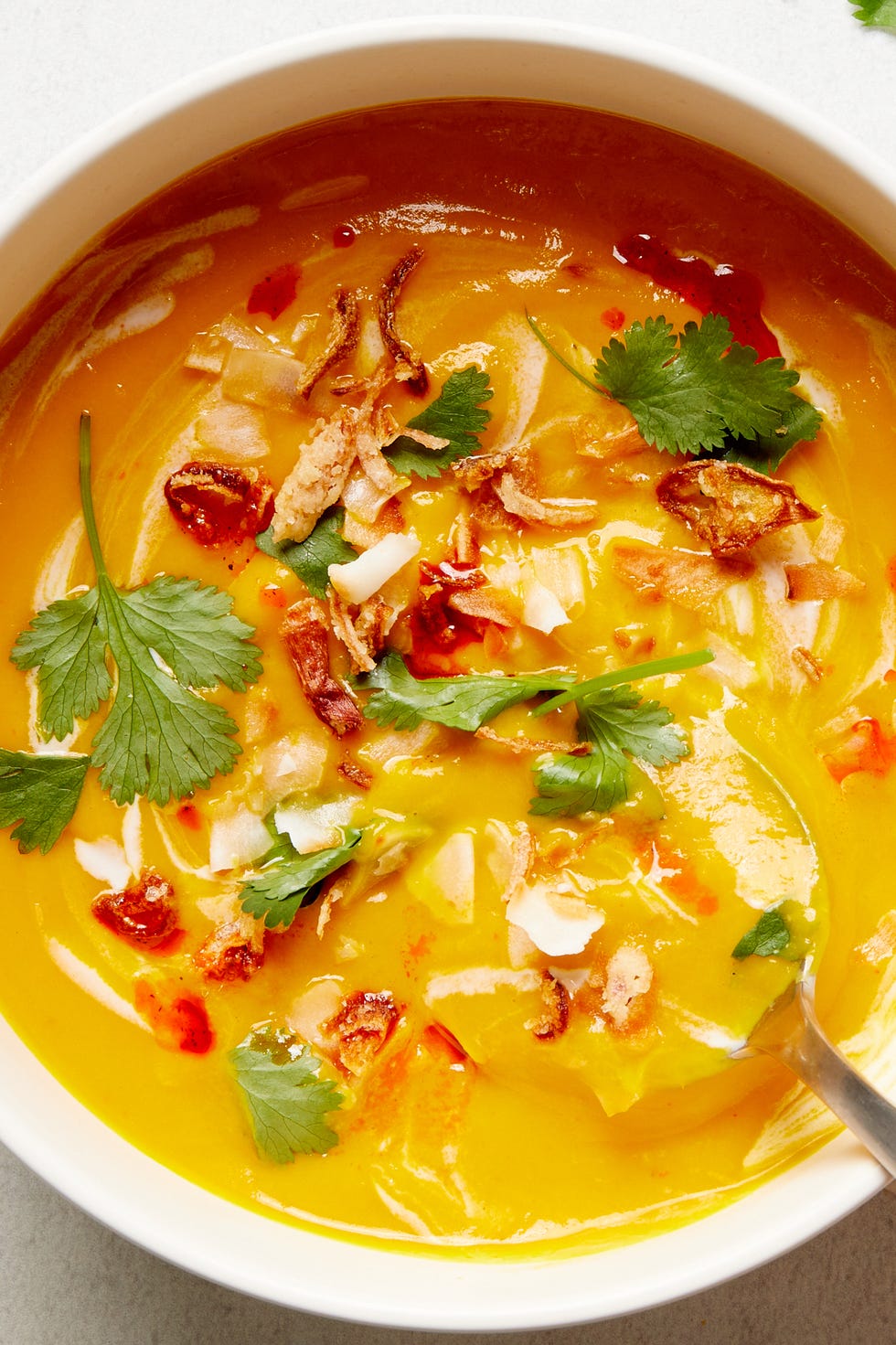 slowcooker vegan butternut squash soup garnished with coconut milk and cilantro