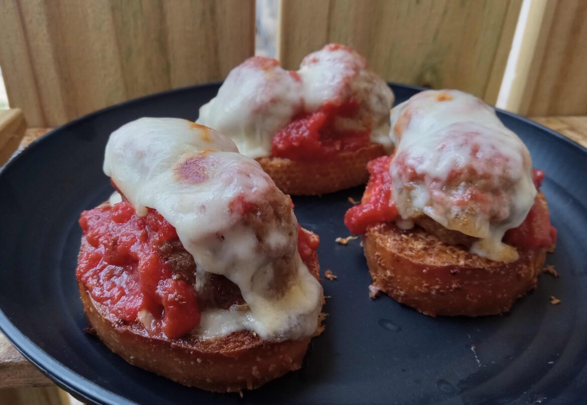 Open-faced meatball sub sliders on toasted garlic and Romano bread with marinara and whole milk motz