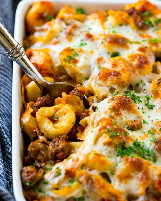 baked tortellini with meat sauce close up with spoon
