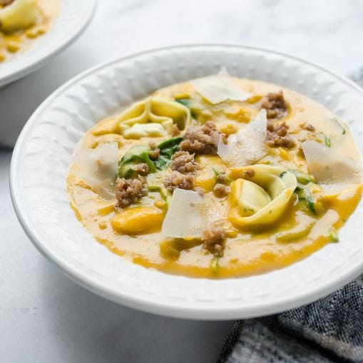 butternut squash sausage and tortelloni soup in white bowl