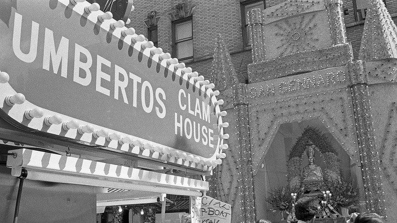 The Umberto's Clam House sign with a San Gennaro festival backdrop