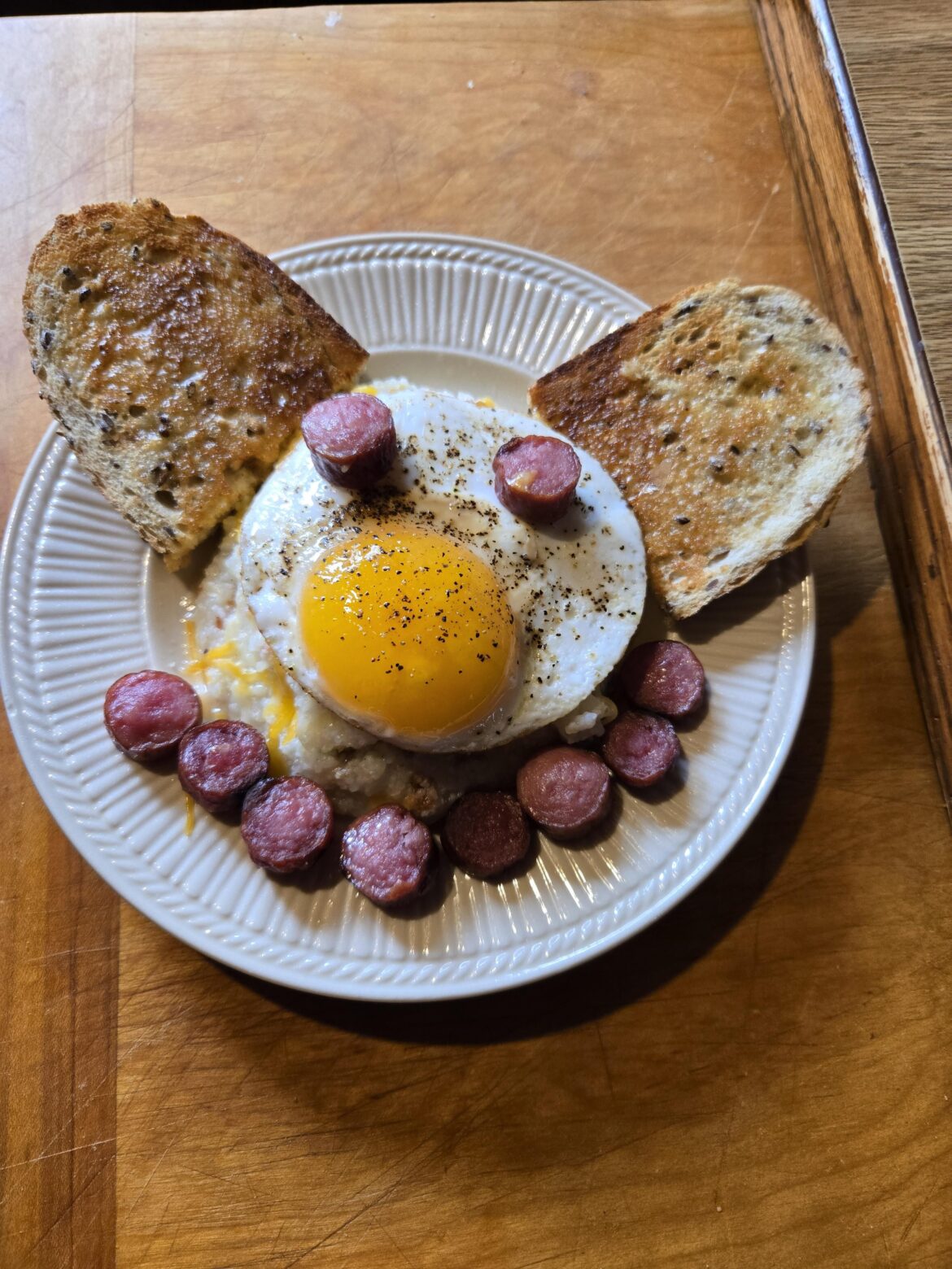 Bacon cheesy grits with a duck egg on it.