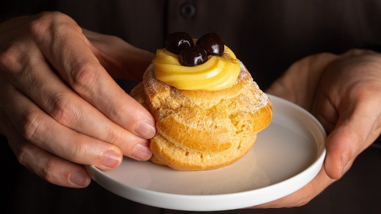 Person holding a zeppole di san Giuseppe