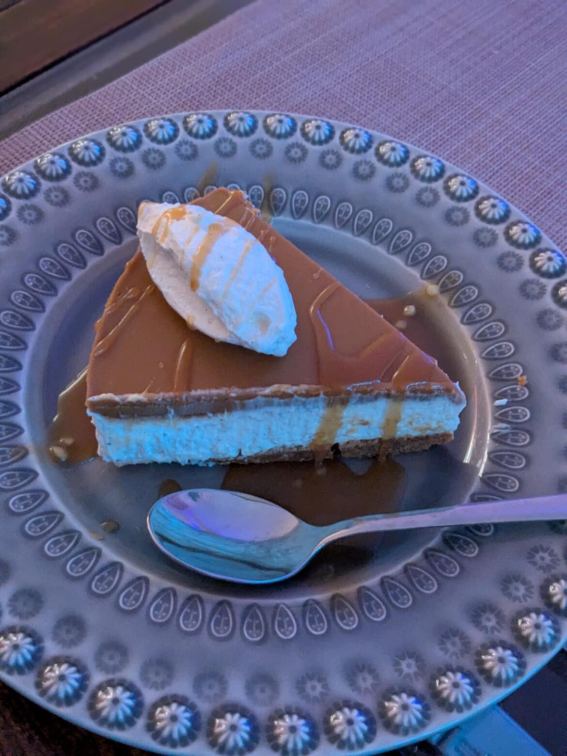 Homemade biscoffcheesecake with whipped cream and caramel sauce