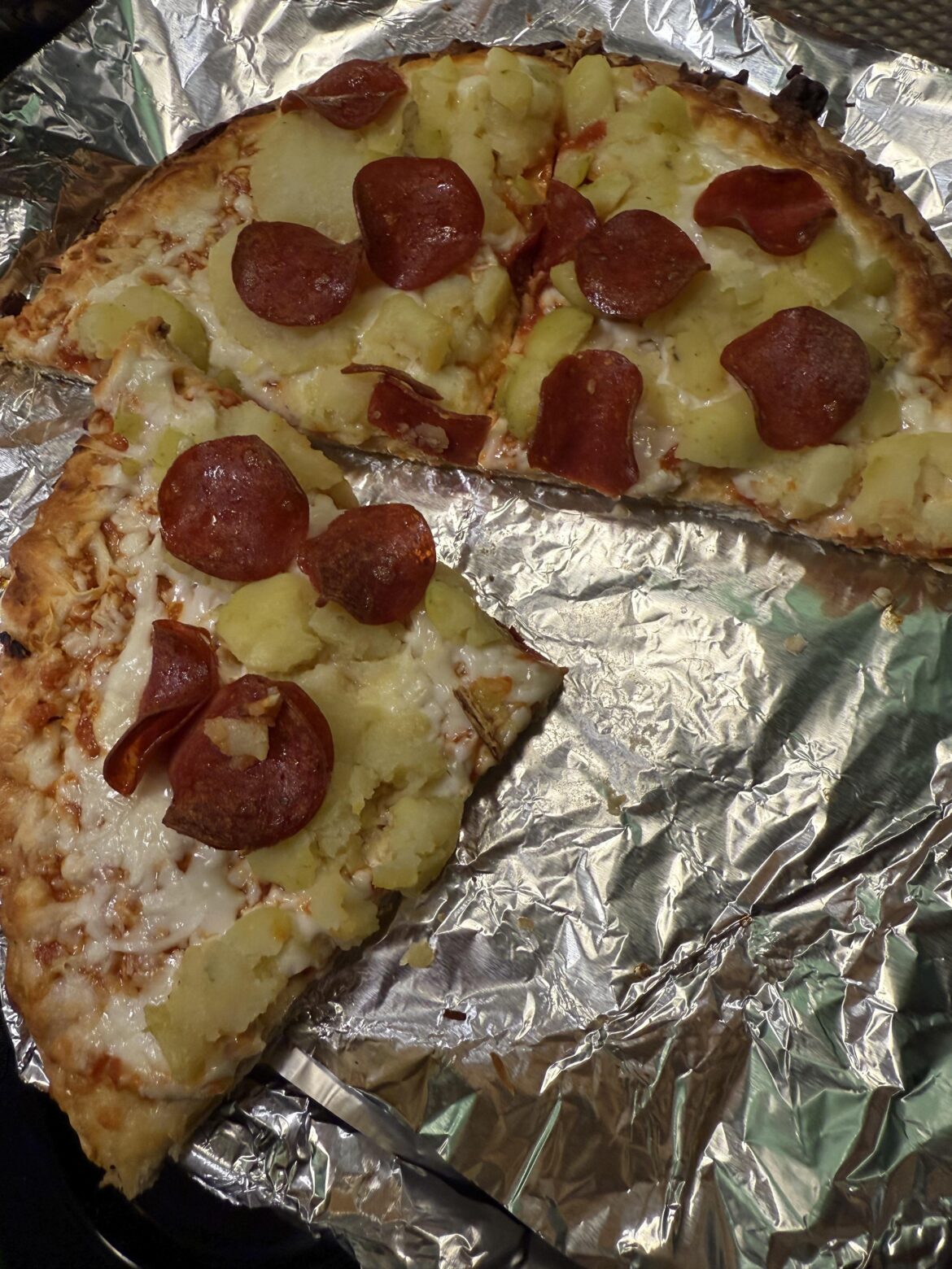 Boiled and smashed potatoes and turkey pepperoni on a frozen cheese pizza