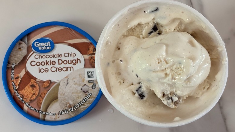 Top-down view of open tub of Great Value Chocolate Chip Cookie Dough ice cream next to lid on white table