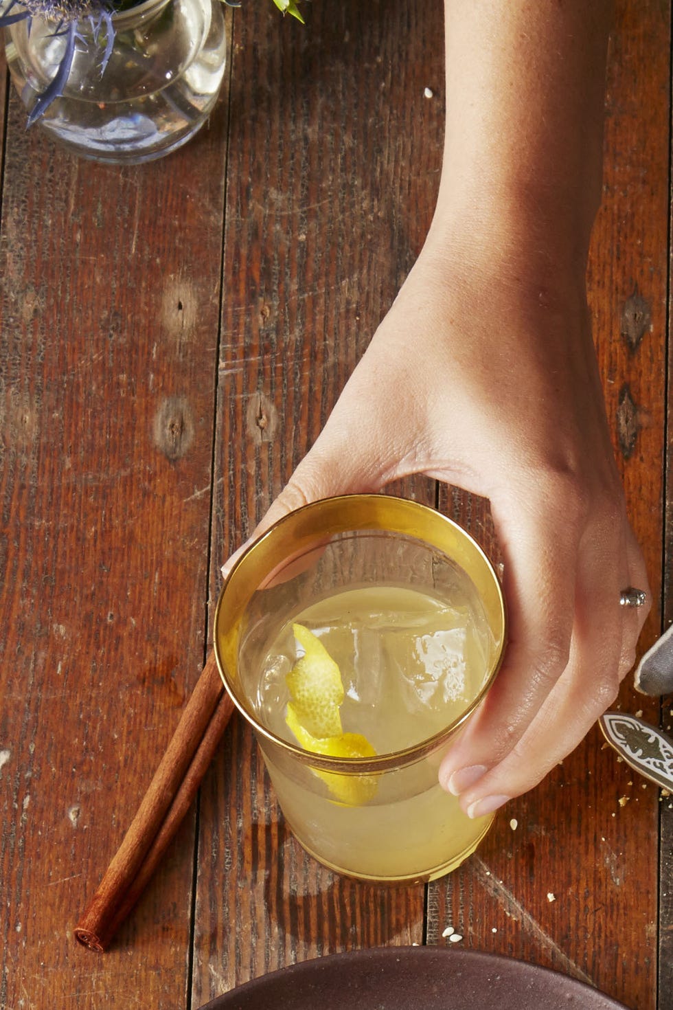 a glass of citrus whiskey punch on a wooden table