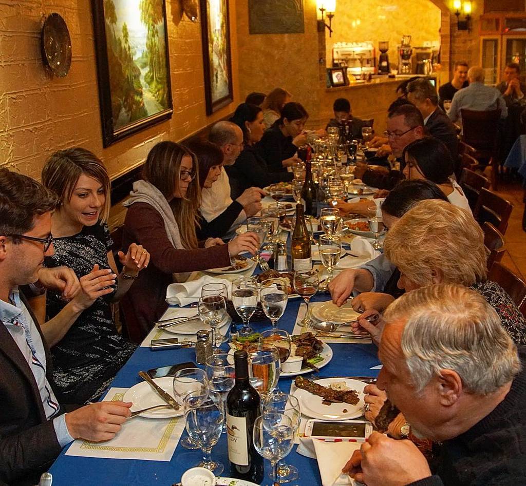 Image shows a large group of diners having dinner at Ephesus Mediterranean Grill in Dallas.