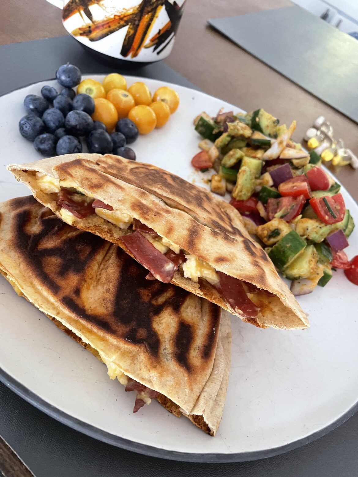 bacon egg and cheese breakfast pitas + berries and side salad w cucumber, onion, tomato, avocado and lemon berbiere “dressing”  🥲