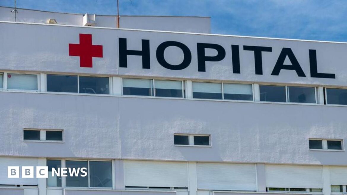 Facade of a French hospital with the red cross and French word Hopital