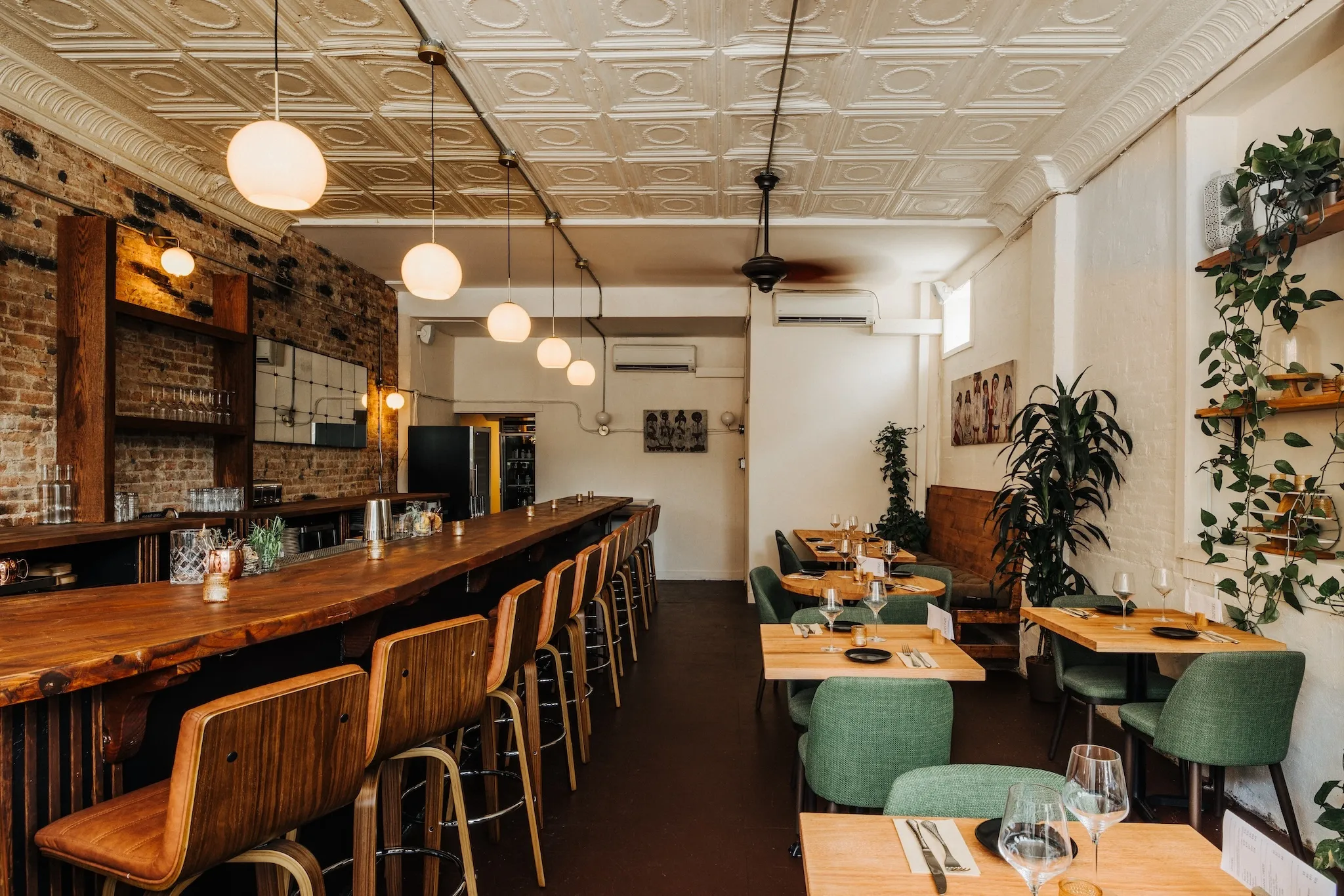 White brick walls, globe lights and a wooden table that runs the length of selune
