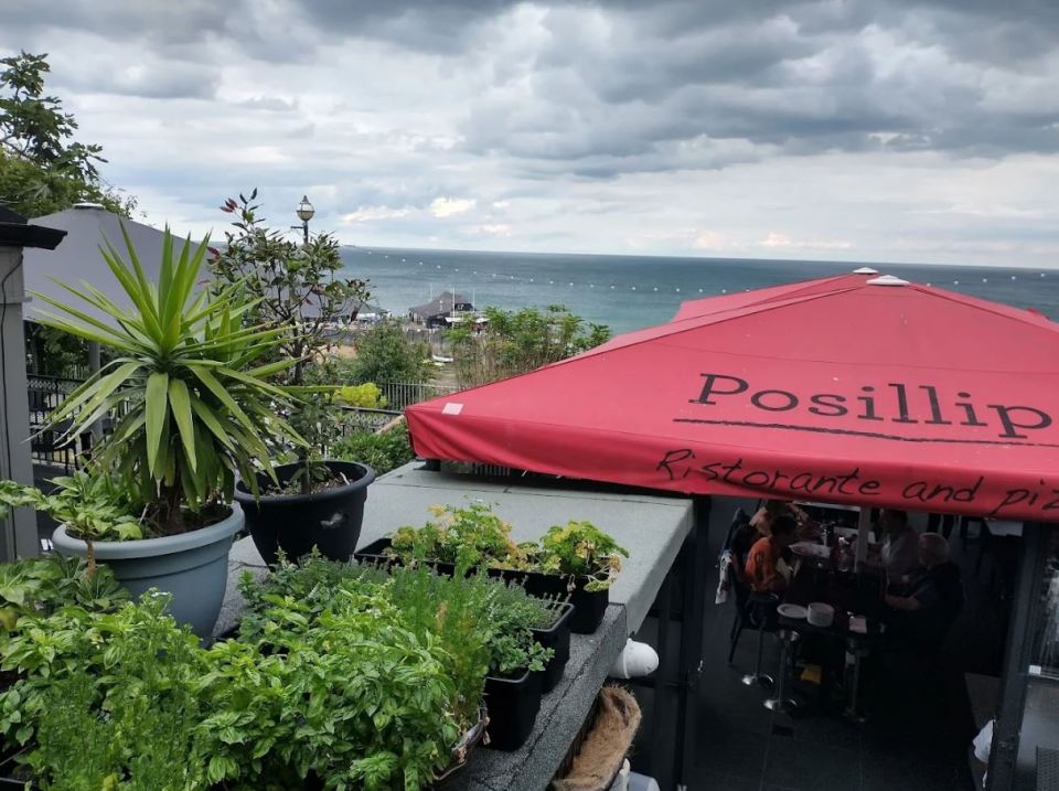 Outdoor patio of Posillipo Ristorante and pizzeria overlooking the ocean.