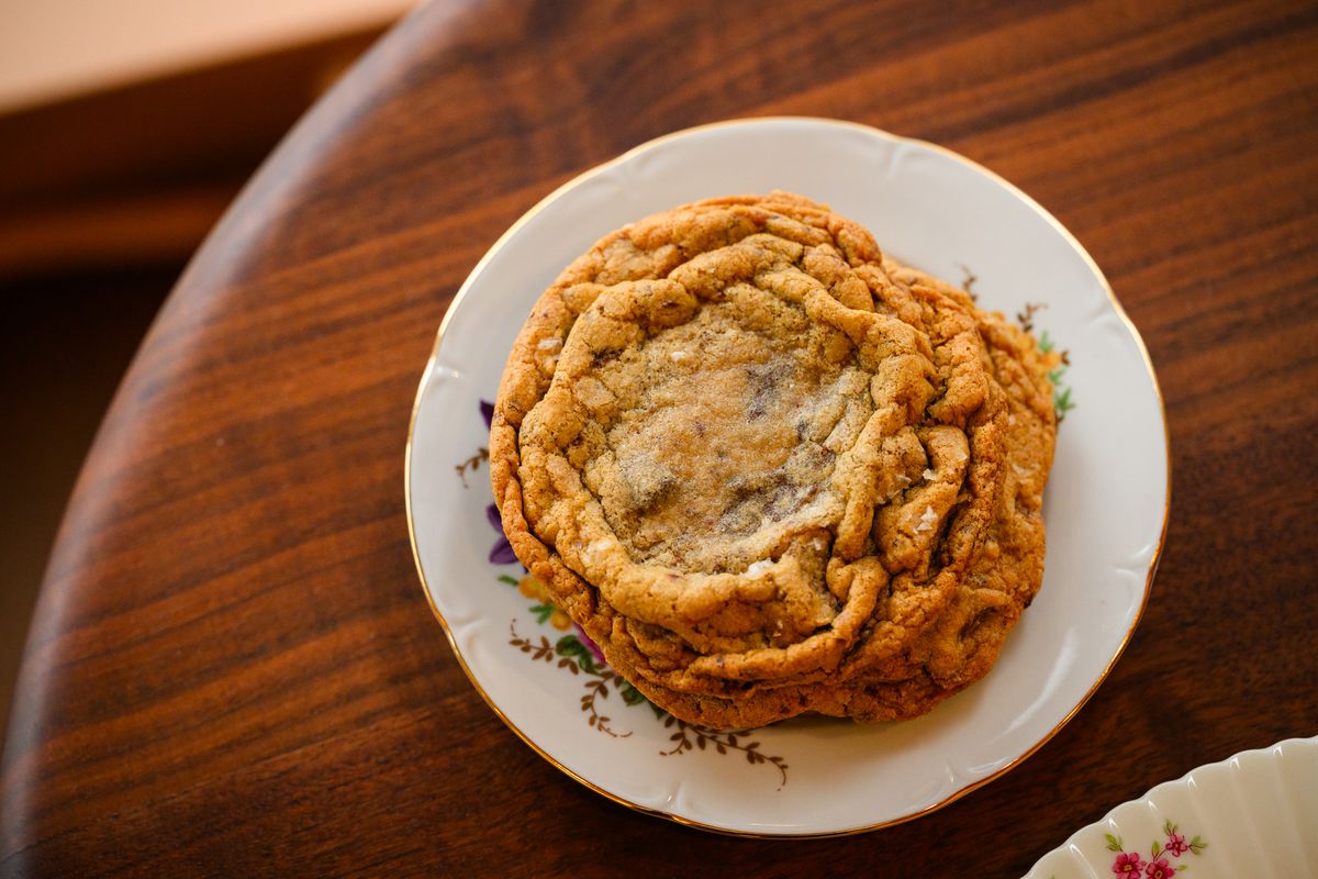 A chocolate chip cookie sits on a plate at Flour Bloom.