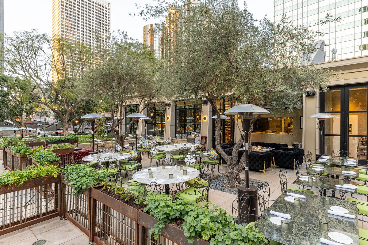 Outdoor patio for Settecento with heaters and lush greenery.