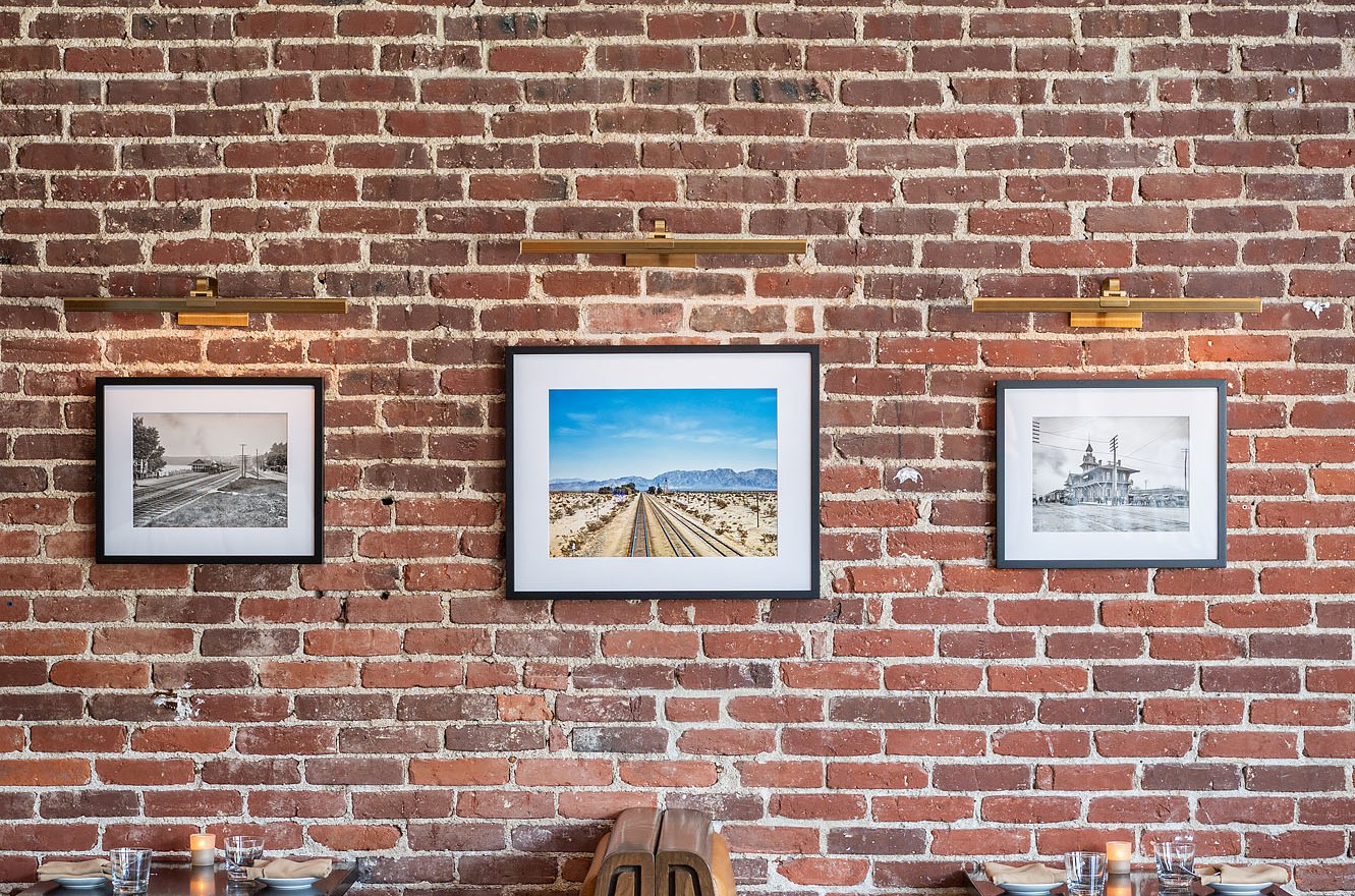 Brick walls, art work, and minimalist tables. 