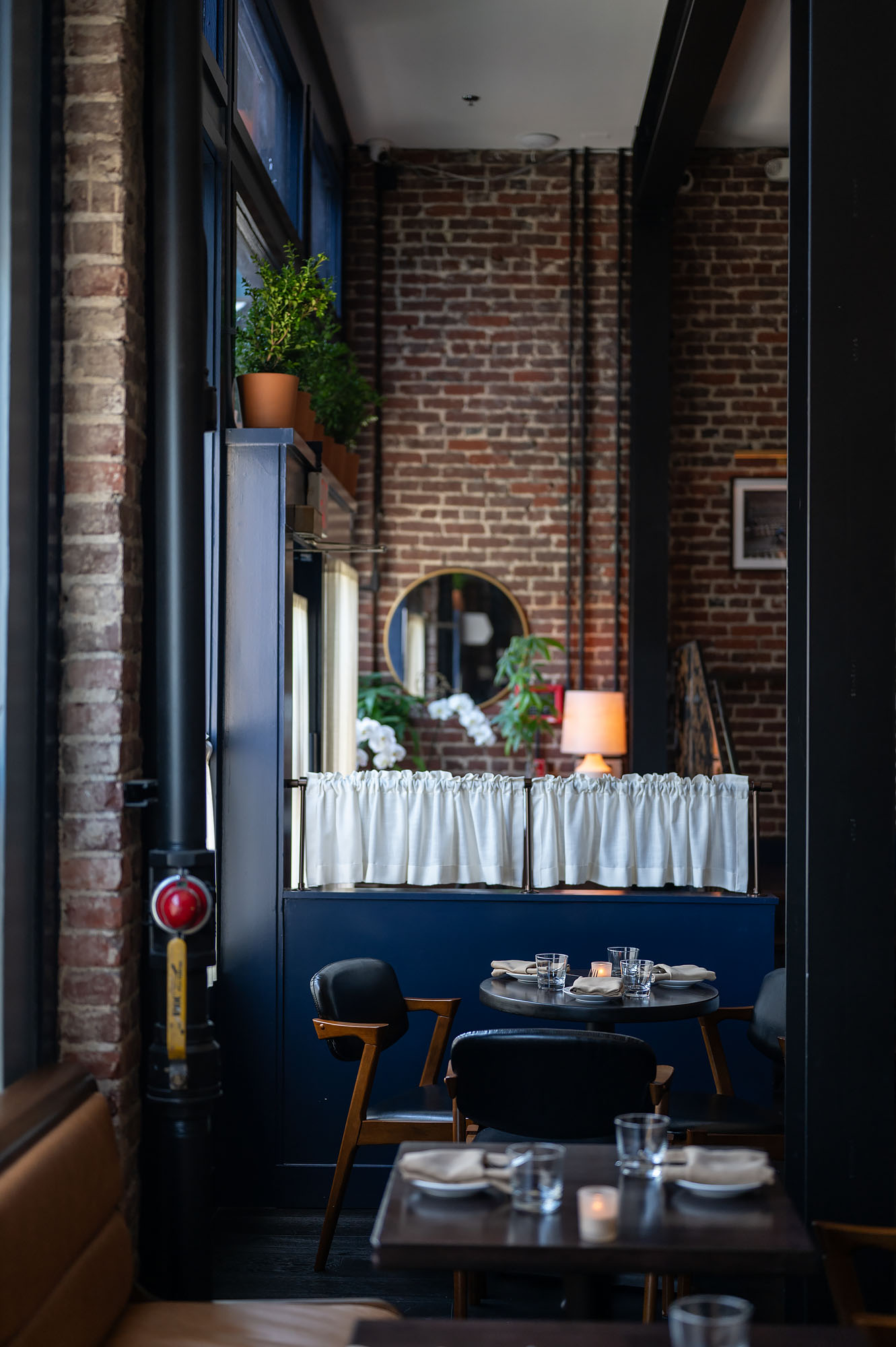 A chic new restaurant with brick walls and blue accents.