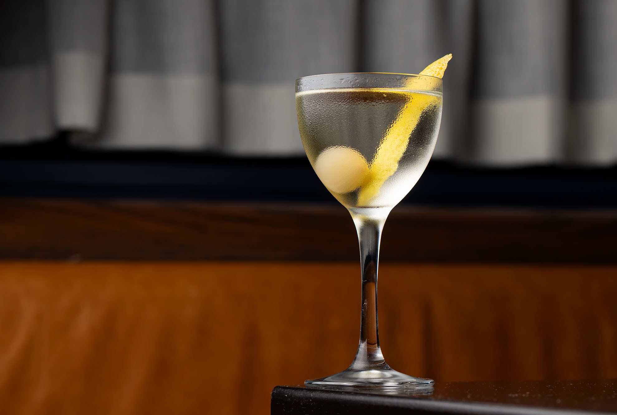 A martini-style cocktail with lemon garnish.