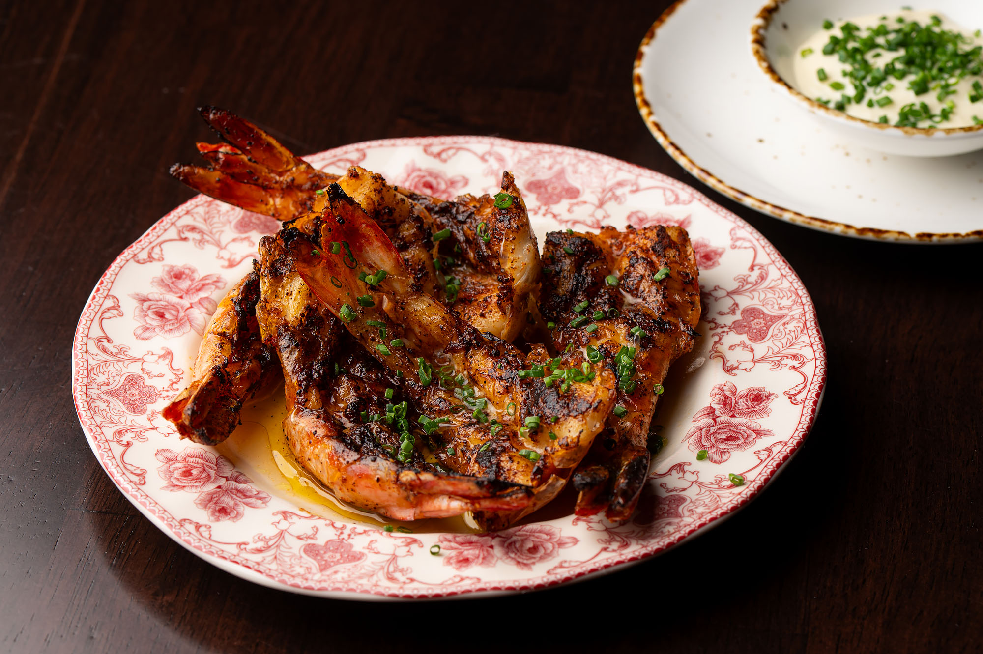 Grilled butterflied prawns on a old fashioned plate.
