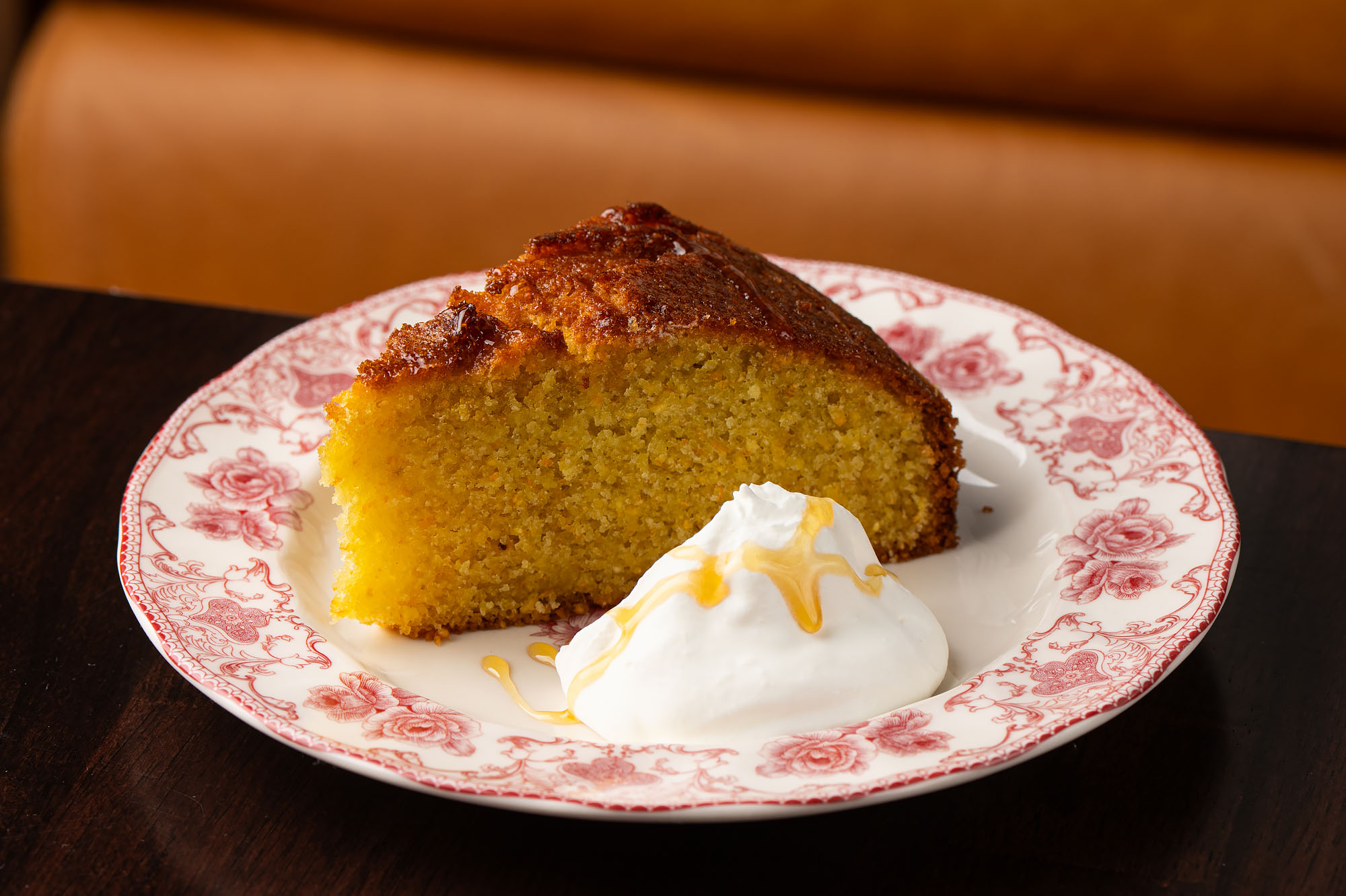 A yellow cake with pile of cream.