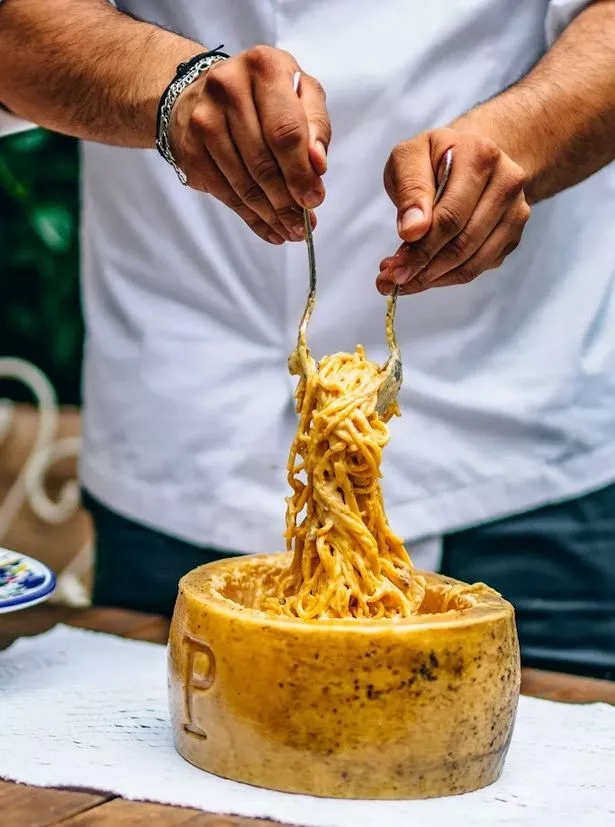 The carbonara pasta served in a giant cheese wheel
