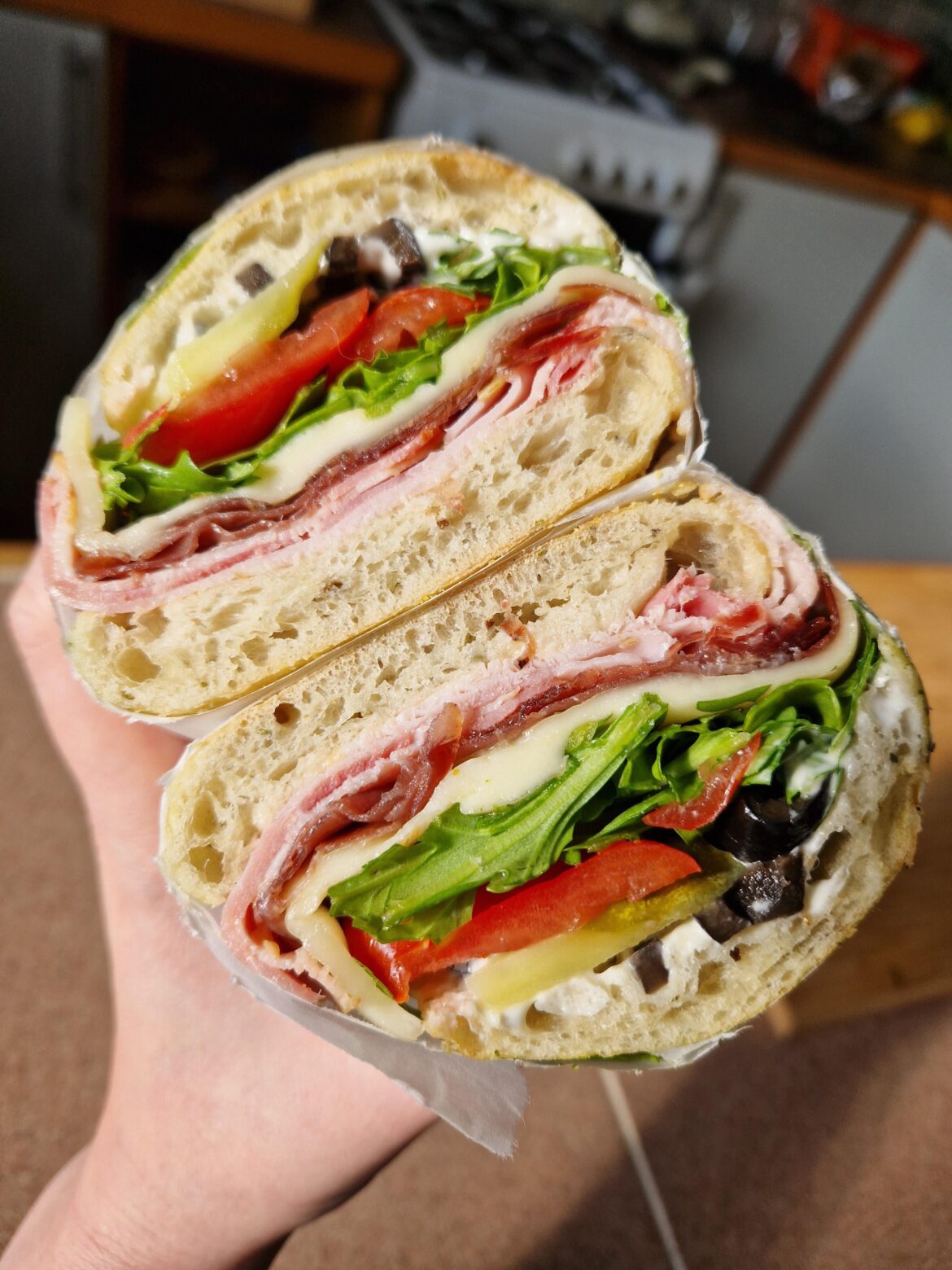 Porchetta, coppa and mozzarella on rosemary sea salt focaccia w/ rocket, san marzano tomatoes, olives and pickles