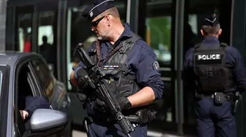 Reuters An armed police officer speaks to a driver through a car window